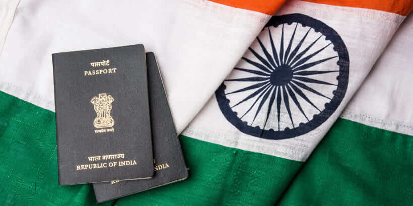 Two Indian passports placed on the Indian flag, representing travel and visa application for India.